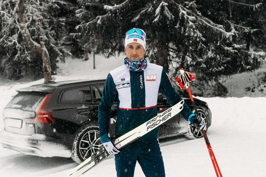 Even Northug holder et par ski foran en svart Volvo
