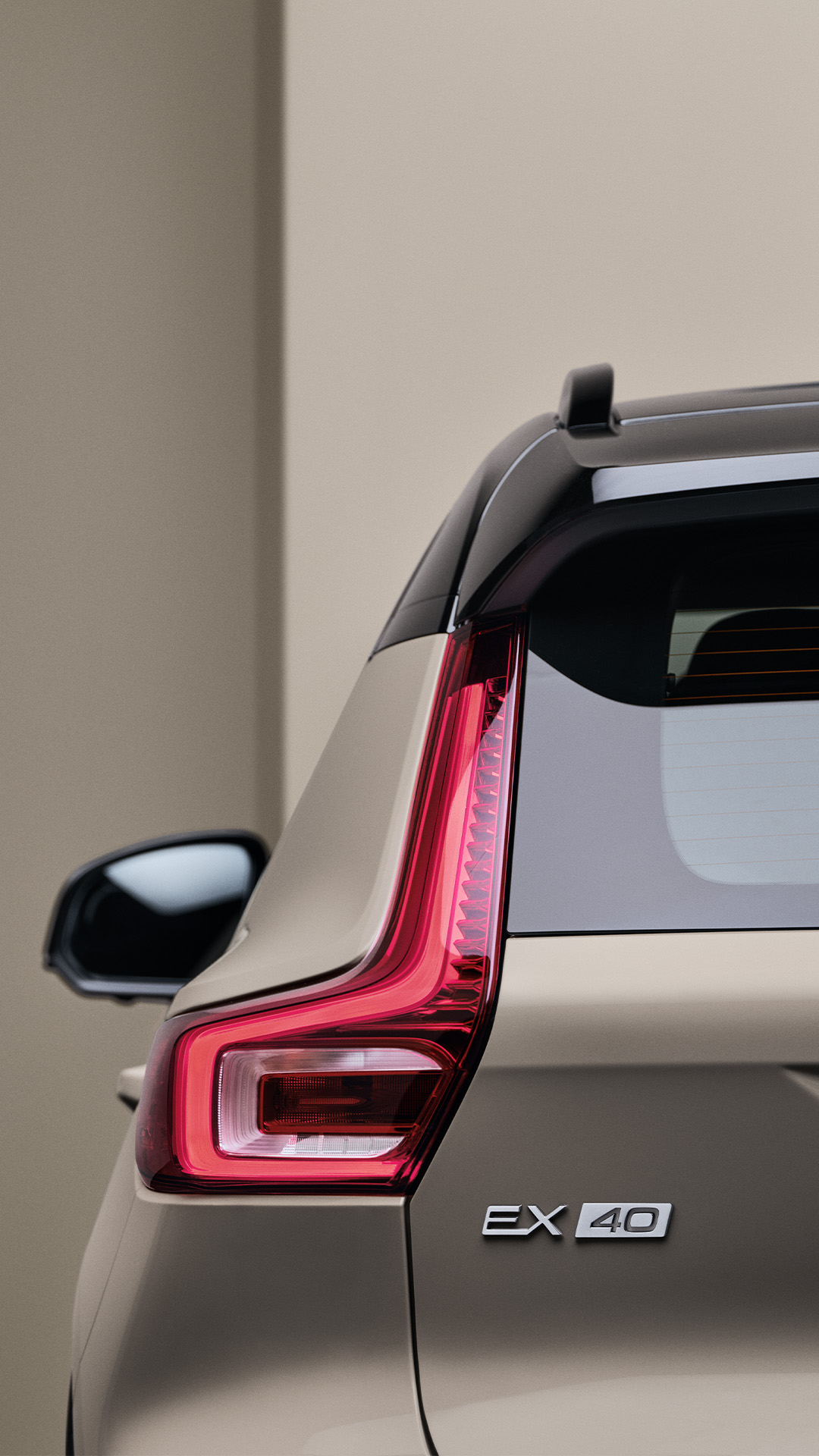 Detaljbilde av ryggelys og bakside på en sandfarget Volvo EX40