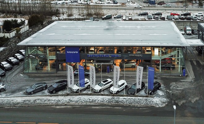 Bygning I glass med parkerte biler utenfor