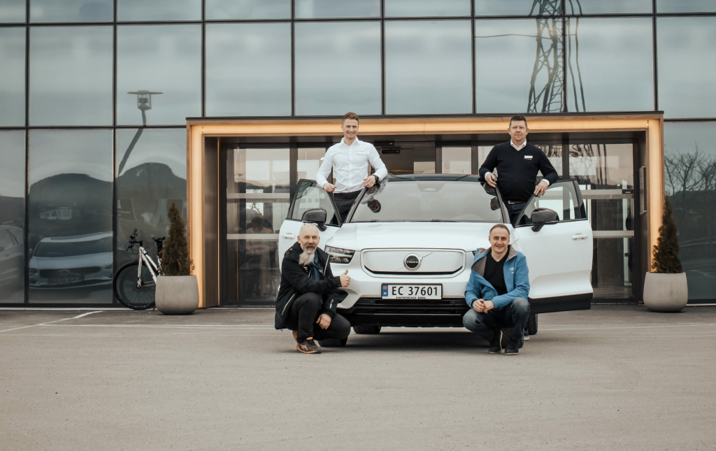Fire menn rundt en hvit Volvo