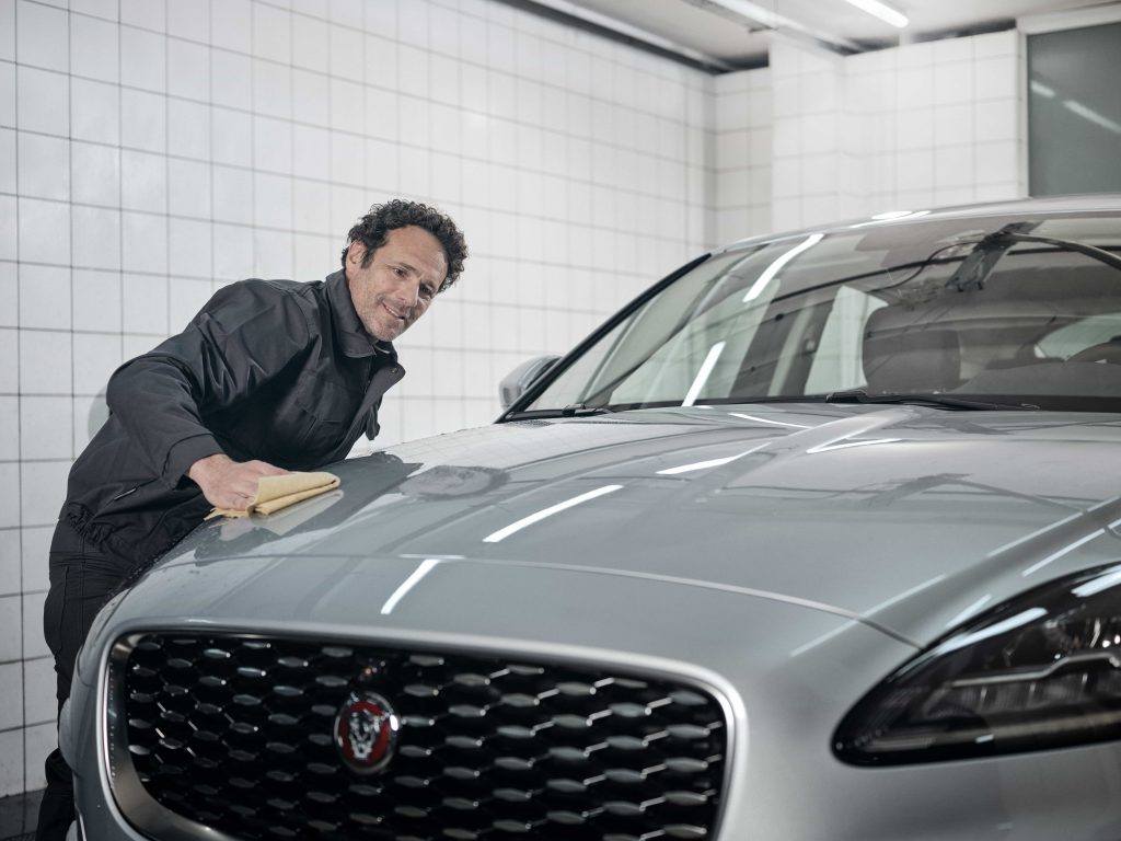 Mann rengjør Jaguar