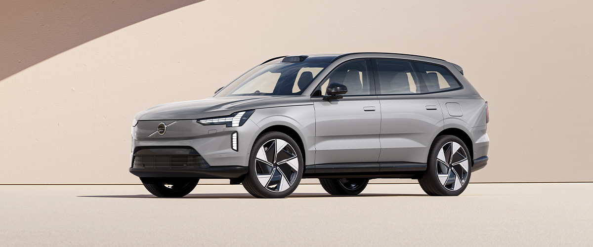 Sølvfarget Volvo EX90 med beige bakgrunn
